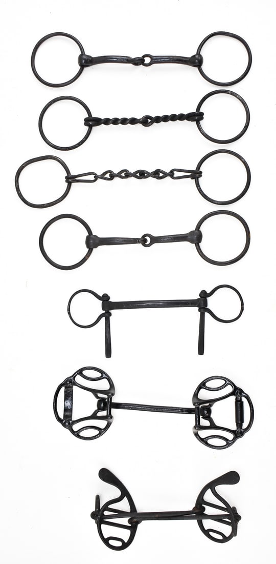 ASSORTMENT OF ANTIQUE CAST IRON HORSE BITS: An assortment of seven cast iron horse bits, circa late 19th- early 20th century. The largest bit measures 8" H x 3.5" W x 4" D.