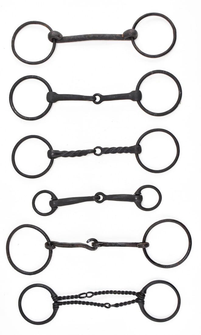 ASSORTMENT OF ANTIQUE CAST IRON HORSE BITS: An assortment of six cast iron horse bits, circa late 19th- early 20th century. The largest bit measures 12" H x 3.25" W x 1" D.