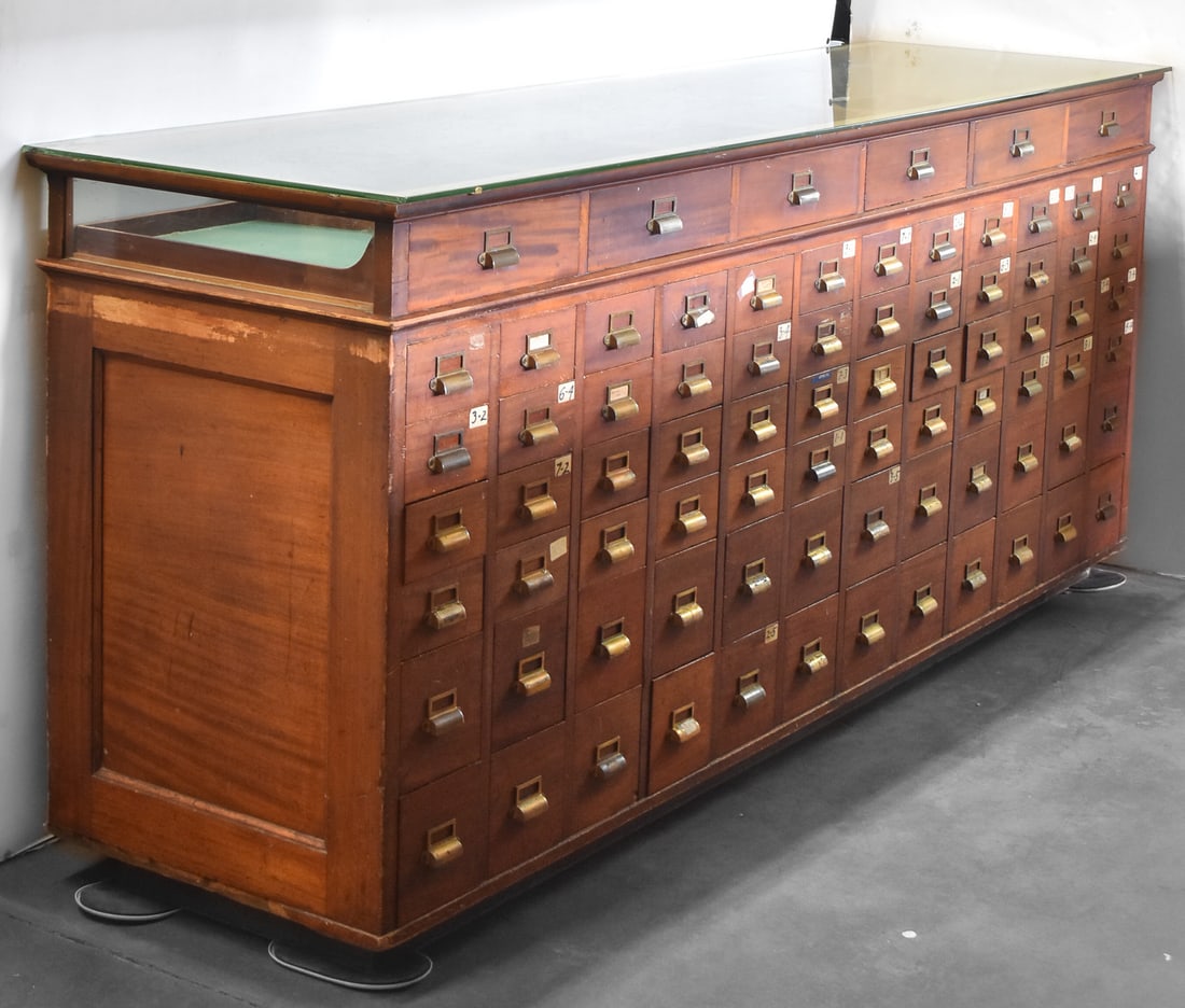 LARGE MULTI-DRAWER MAHOGANY STORE DISPLAY HARDWARE CABINET: A large multi-drawer store display hardware cabinet with a glass display top and felted display drawers, circa late 19th century. The cabinet is made of mahogany with brass hardware. This cabinet