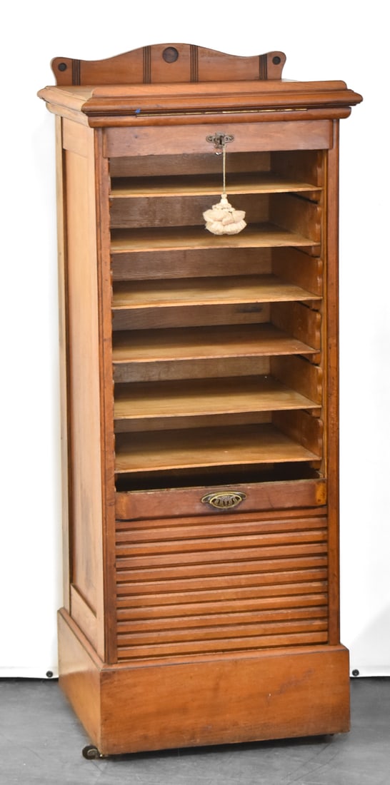 OAK TAMBOUR FILE CABINET: Cabinet is made of oak wood with a vertically rolling (tambour) door to reveal eight filing slots inside. Comes with locking key. Cabinet measures 48" H x 19.5" W x 17.5" D.