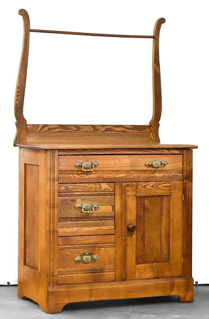 OAK WASHSTAND WITH TOWEL BAR; CIRCA EARLY 20TH CENTURY: An oak washstand with three drawers, side cabinet, towel bar, circa early 20th century. The item measures 51" H, 29" W, 15.5" D.