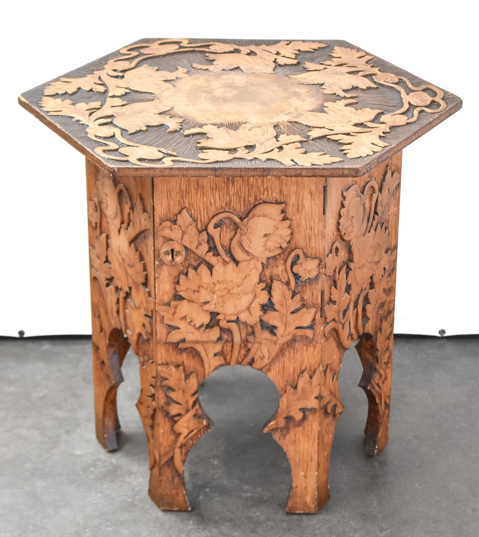 ART NOUVEAU PYROGRAPHY TABORET: An Art Nouveau pyrography taboret with a central cabinet, circa early 20th century. The item measures 25" H x 27.5" W x 24" D.