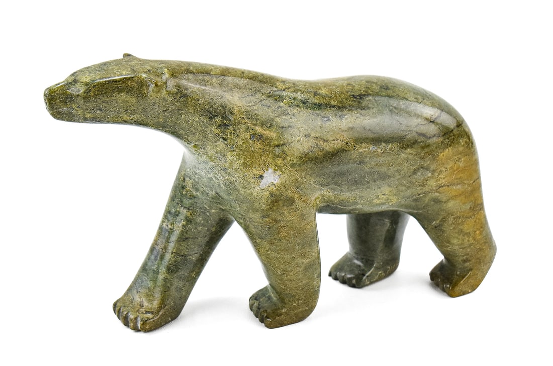 INUIT CARVED SERPENTINITE STONE POLAR BEAR: A Inuit carved serpentinite stone polar bear marked "Carving #9795269" and "Canada Eskimo Art" (trademark owned by the Inuit Art Foundation, Canada) with stickers on the base of the paws. The polar
