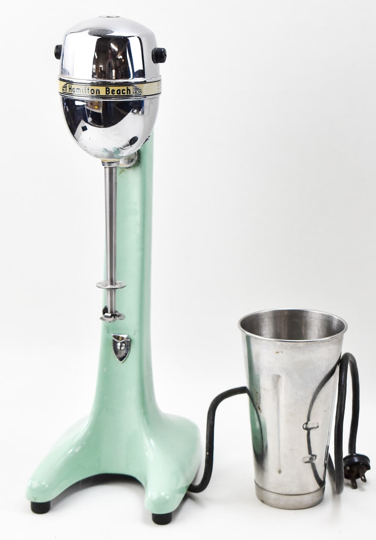 HAMILTON NO. 33 JADEITE GREEN ENAMEL MILKSHAKE MIXER: A Hamilton No. 33 milkshake mixer with Jadeite Green enamel, circa mid-20th century. This lot includes one milkshake tin. The mixer measures 18" H x 6" W x 8" D.