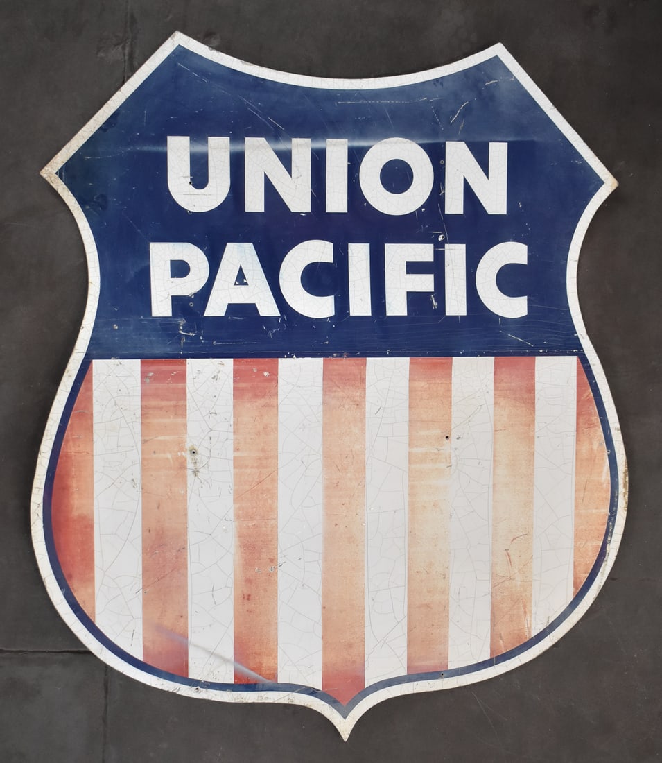 20TH CENTURY UNION PACIFIC SHIELD RAILROAD SIGN: A Union Pacific railroad shield sign with a signed new school graffiti style spray-painted cat advertisement on the reverse, circa 20th century. The item measures 62.5" H, 55" W, 1.5" D.