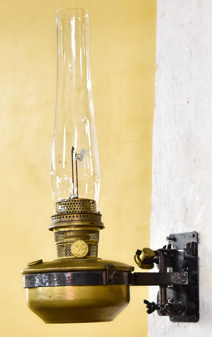 ALADDIN MODEL B WALL MOUNT CABOOSE KEROSENE LAMP: An Aladdin Model B brass wall mount caboose kerosene lamp manufactured during WWII-era, circa late 1930s. The lamp measures 18" H x 8" W x 11" D.