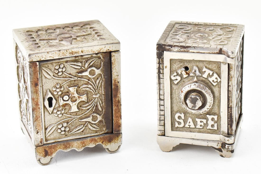 PAIR OF VINTAGE COIN BANK SAFES: A pair of vintage steel coin bank safes. One of the safes is marked "State Safe" on the front, and the other is marked on the base "Key Lock Safe No. 50" manufactured by the J & E Stevens Company