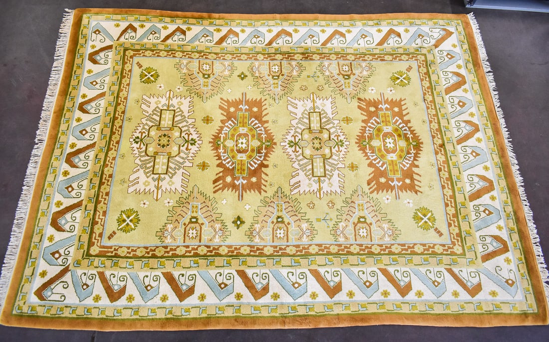 HANDWOVEN PEKING DESIGN WOOL RUG: A handwoven Peking design wool rug, made in India. The rug is in gold ivory color with light blue and light brown accents and geometric designs. The rug measures 150" L x 106" W.