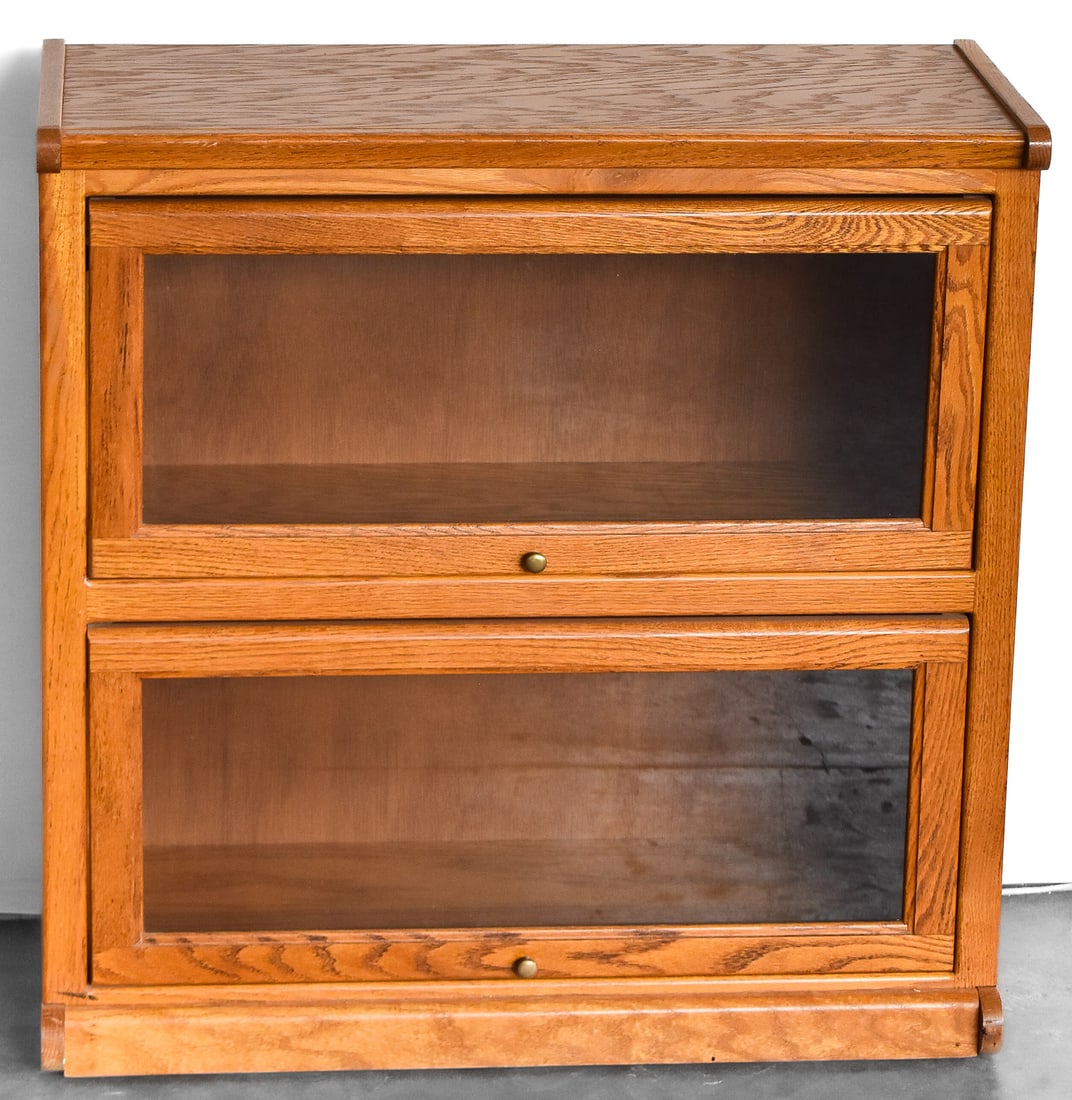 TWO-TIER OAK BARRISTER BOOKCASE: A two-tier oak barrister bookcase made the the Oak Warehouse in Eugene, Oregon circa late 20th century. The bookcase measures 33" H x 32.5" W x 13.5" D.