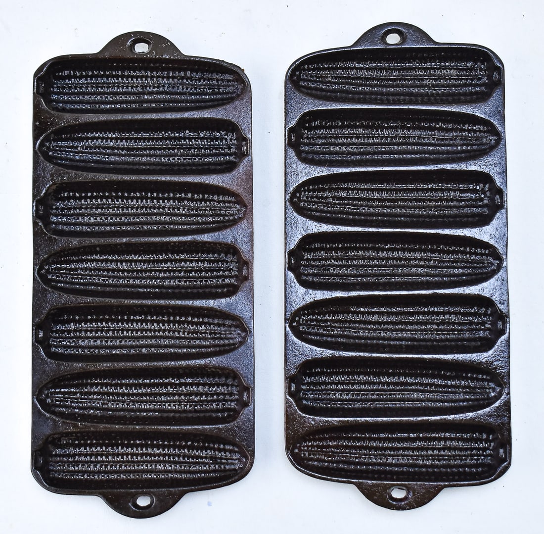 PAIR OF WAGNER KRUSTY KORN KOBS CAST IRON BAKING TRAY: A pair of Wagner Krusty Korn Kobs cast iron baking trays. Marked on the base and patented 1920. Each tray measures 13" H x 6" W x 1" D.