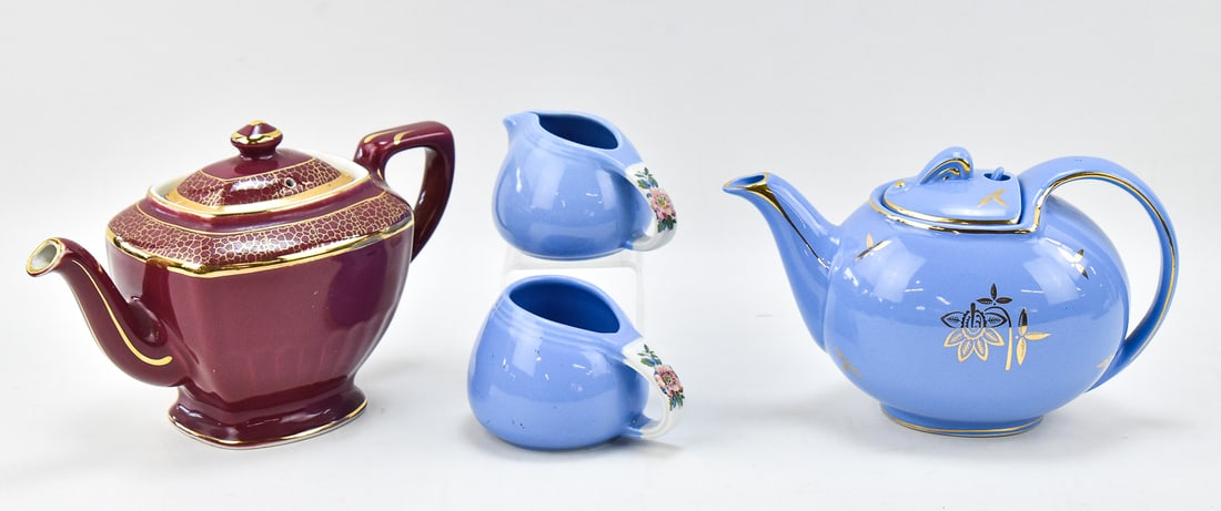 HALL POTTERY ASSORTMENT: An assortment of Hall pottery including a hook cover six cup teapot in periwinkle color, a six cup "Hollywood" teapot, and two "Rose Parade" pattern creamers. The Hollywood teapot measures 6.5" H x 10
