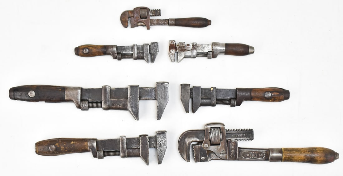 SEVEN WOOD HANDLED PIPE WRENCHES: Ages of wrenches range from 1884 to 2016. Wrenches range from 2.74" openings to 6" openings. Largest wrench measures 12.25" H x 3" W x 1.25" D from top of wrench to bottom of the handle.