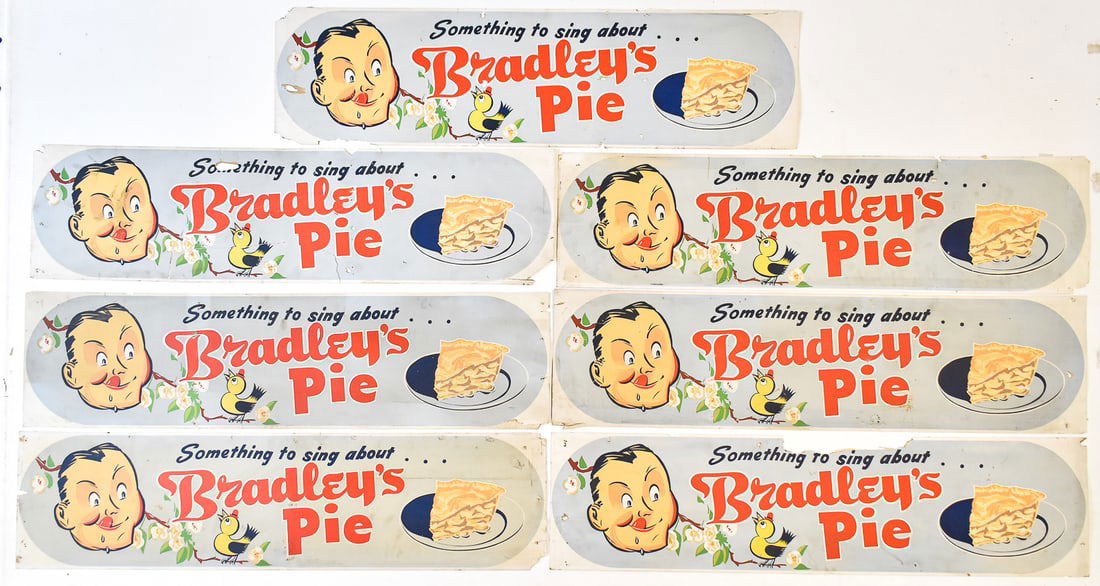 SEVEN 'BRADLEY'S PIE' TROLLEY CAR ADVERTISNG SIGNS: Seven "Something to sing about...Bradley's Pie - !" WWII era trolley car advertising signs measuring 11" H x 42" W x 0.25" D.