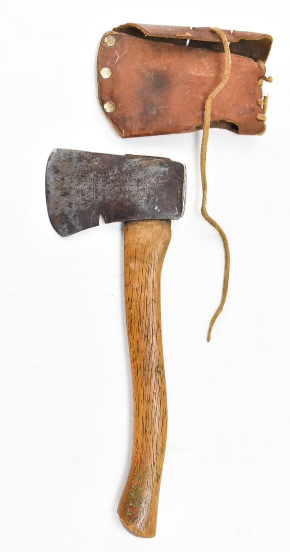 BOY SCOUTS OF AMERICA 'GENUINE PLUMB' HATCHET: A Boy Scouts of America "Genuine Plumb" hatchet with nail puller and a leather sheath, circa mid 20th century. The item resting measures 1.5" H, 6.5" W, 14.5" D.