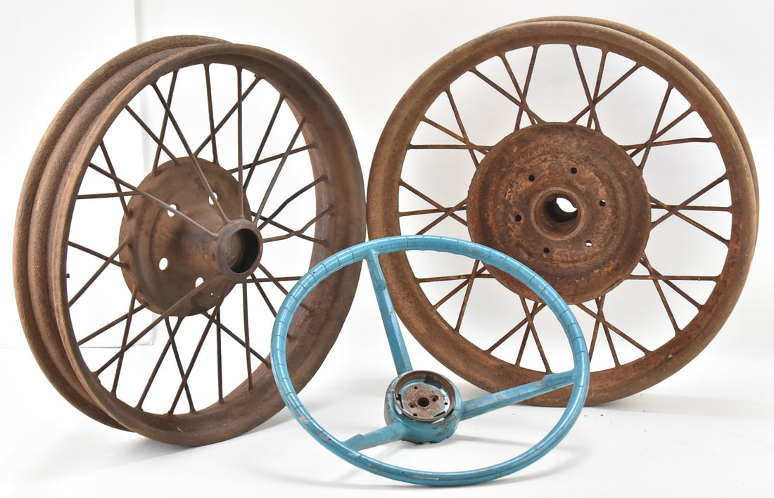 VINTAGE STEERING WHEEL & ANTIQUE WHEELS: FORD MODEL A: A vintage mid-century blue steering wheel and two antique wheels, one of which is likely from a Ford Model A. The Ford Model A wheel measures 22" H x 22" W x 4" D.