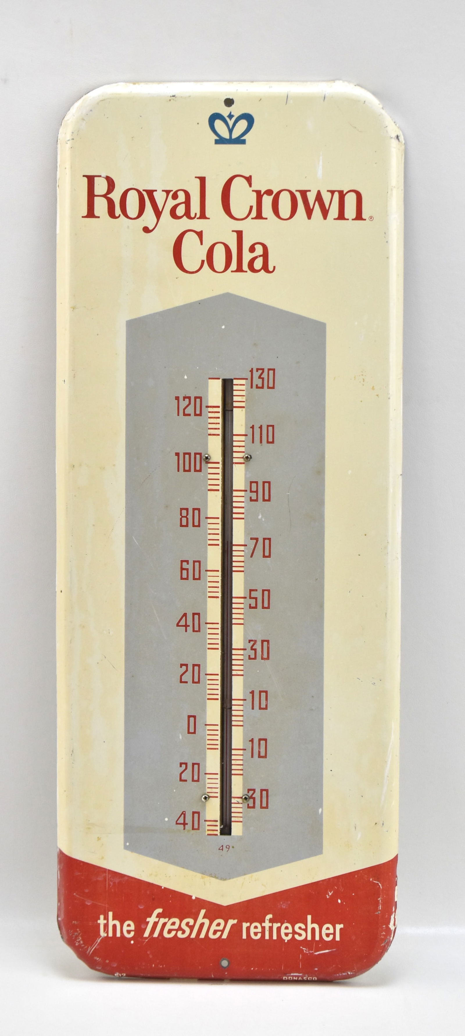 ROYAL CROWN COLA THERMOMETER: Metal RC Cola sign with glass thermometer incased. The sign measures 25.5" H x 10" W x 1" D.
