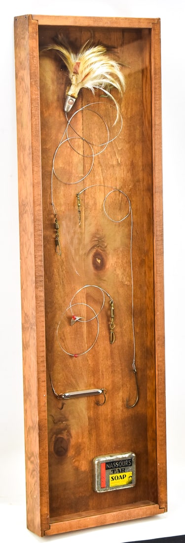 20TH CENTURY SHADOW BOX FISHING ASSORTMENT: A fishing assortment within a shadow box including: Nassour's tar soap dated 1930, a Japanese trolling tuna lure circa mid to late 20th century, and various hooks. The item measures 2.5" H, 11" W,