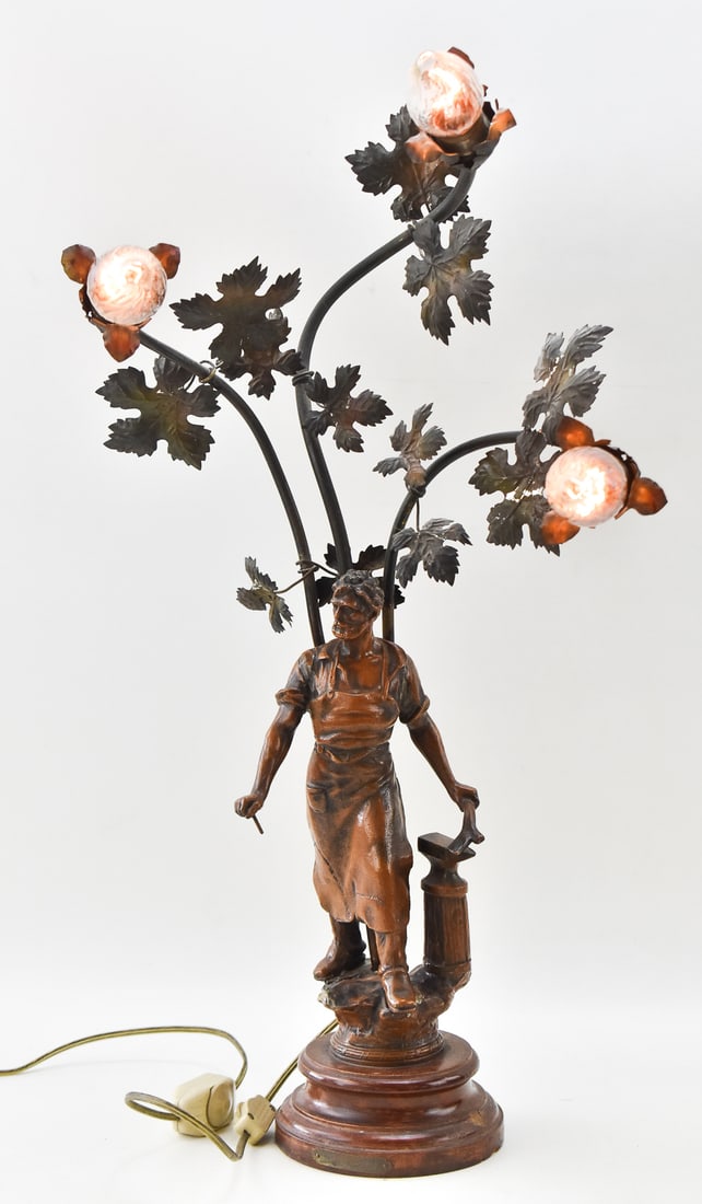 FRENCH ART NOUVEAU SPELTER FIGURAL LAMP: A French Art Nouveau spelter figural lamp of a man with tools or blacksmith, measuring 28" H x 16" W x 12" D.
