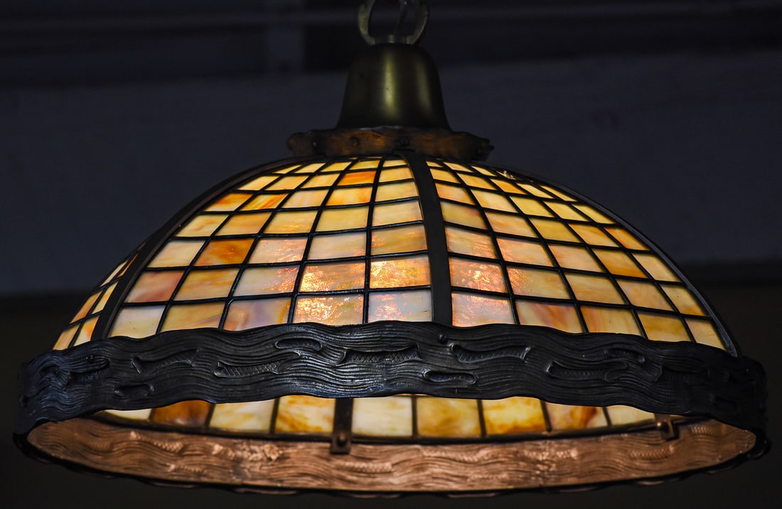 SLAG GLASS CHANDELIER, EARLY 20TH CENTURY: A slag glass chandelier with a faux tree trunk rim, circa early 20th century. The item measures 15" H, 25" W, 25" D.