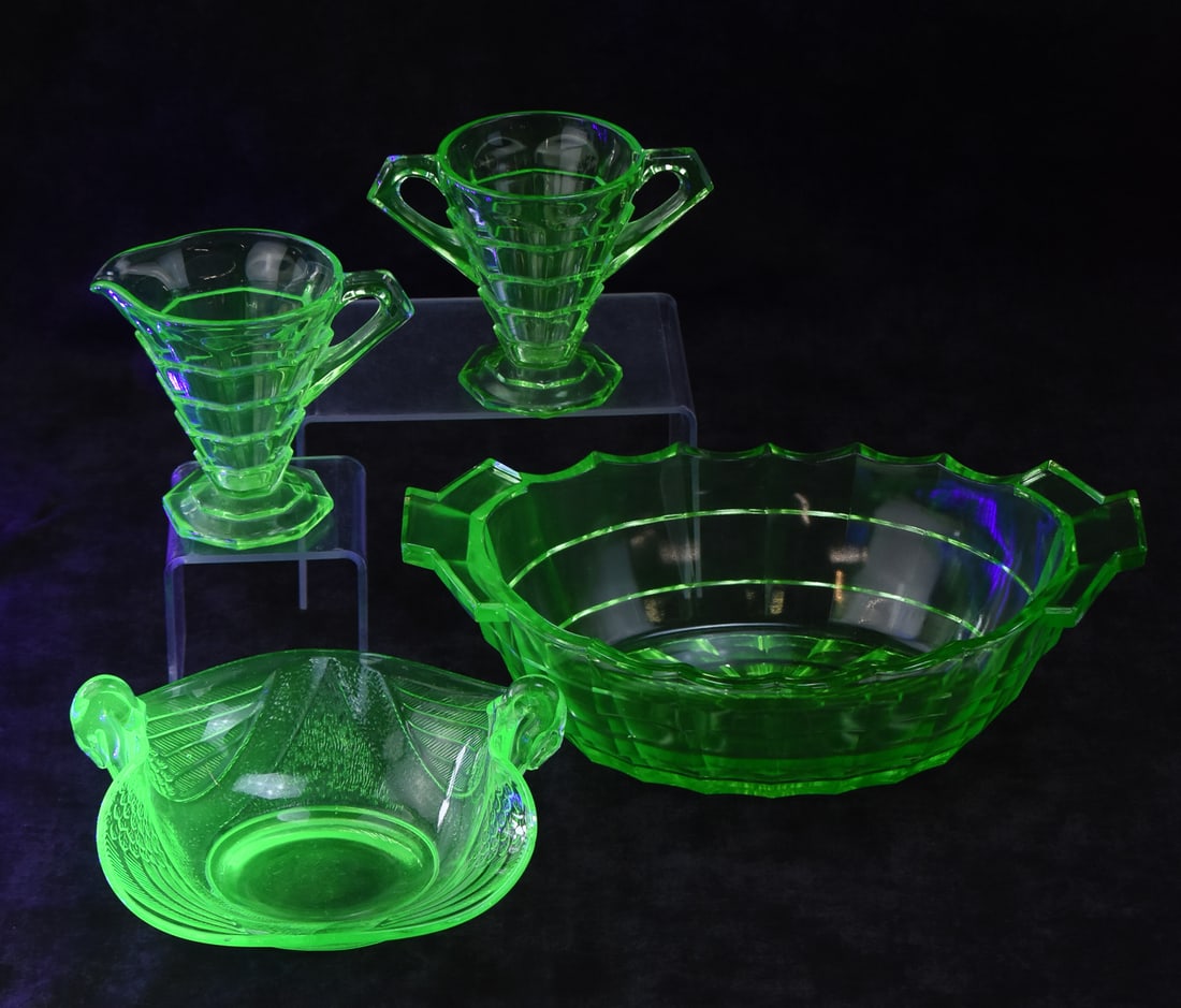 URANIUM DEPRESSION GLASS ASSORTMENT: INDIANA GLASS & FENTON: An assortment of uranium depression glass including an Indiana Glass "Tea Room" pattern creamer and sugar dish and large bowl, and a Fenton double swan candy dish. The large bowl measures 3.5" H x 11"
