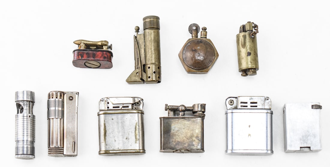 ASSORTMENT OF 10 ANTIQUE AND VINTAGE LIGHTERS: STERLING SILVER, TRENCH LIGHTERS: An assortment of ten antique and vintage lighters including a B. J. Co. sterling silver lighter made in Mexico (69.5 grams), two Beattie Jet lighters circa 1950s, WWI trench art nut lighter with a Geo