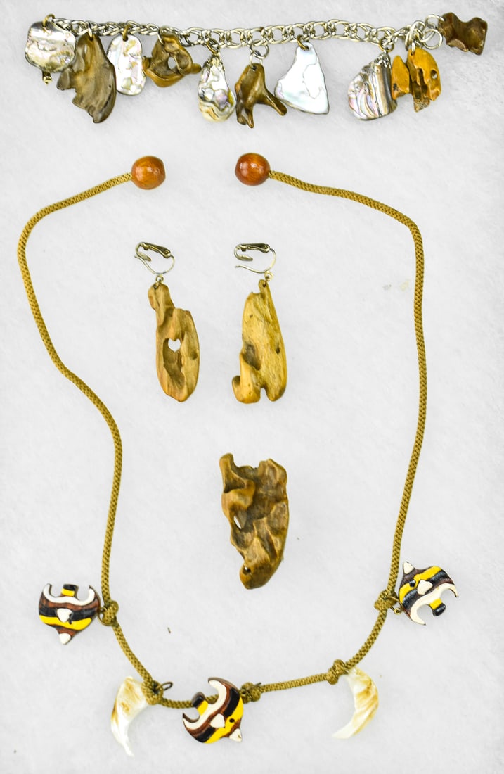 WOOD & SHELL JEWELRY: An assortment of wood and shell jewelry including a cord necklace with painted wooden fish and shell charms, two driftwood crafted earrings, a driftwood pin, and a metal bracelet with polished driftwo
