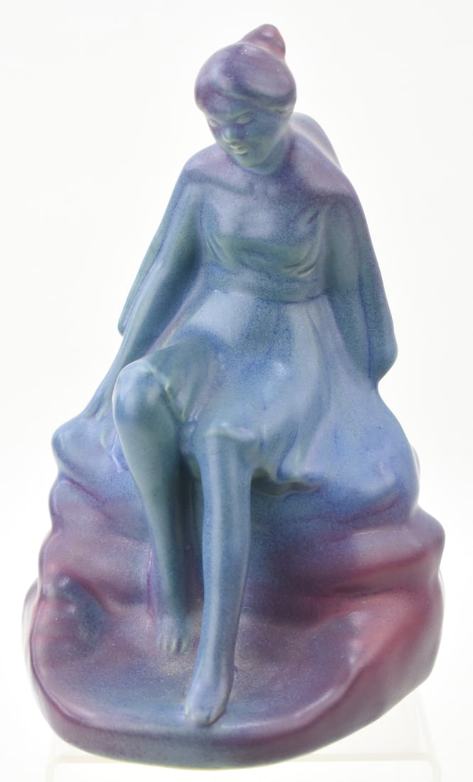 VAN BRIGGLE 'DAY DREAMER' MULBERRY FIGURE: A Van Briggle marked "Day Dreamer" figure in mulberry glaze, circa early - mid 20th century. The item measures 9" H, 6" W, 6" D.