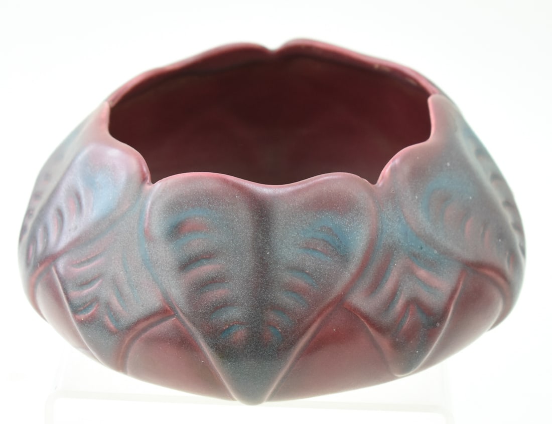 VAN BRIGGLE MARKED PHILODENDRON LEAF PATTERNED 'PERSIAN GLAZE' LOW BOWL: A Van Briggle marked philodendron leaf pattern low bowl in "Persian Rose" glaze, circa 1940-1960s. The item measures 3" H, 6.5" W, 6" D.