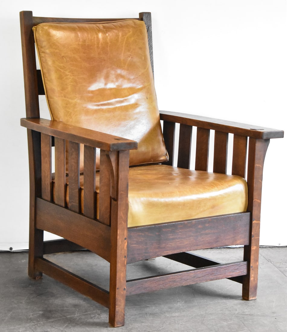 STICKLEY MISSION OAK ARTS AND CRAFTS LOUNGE CHAIR, C. EARLY 1900s.: A Mission oak Arts and Crafts lounge chair made by Stickley, circa early 1900s. The chair has a sturdy oak construction and leather cushions. The makers tag has fallen off. The chair measures 41" H x 