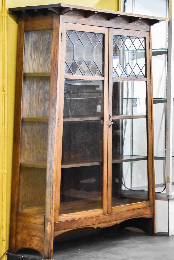 ARTS AND CRAFTS MISSION OAK GLASS FRONT DISPLAY CABINET: An Arts and Crafts Mission oak glass front display cabinet originating from Chicago, Illinois circa early 20th century. There is a partial maker's label on the back of the piece. The cabinet features 
