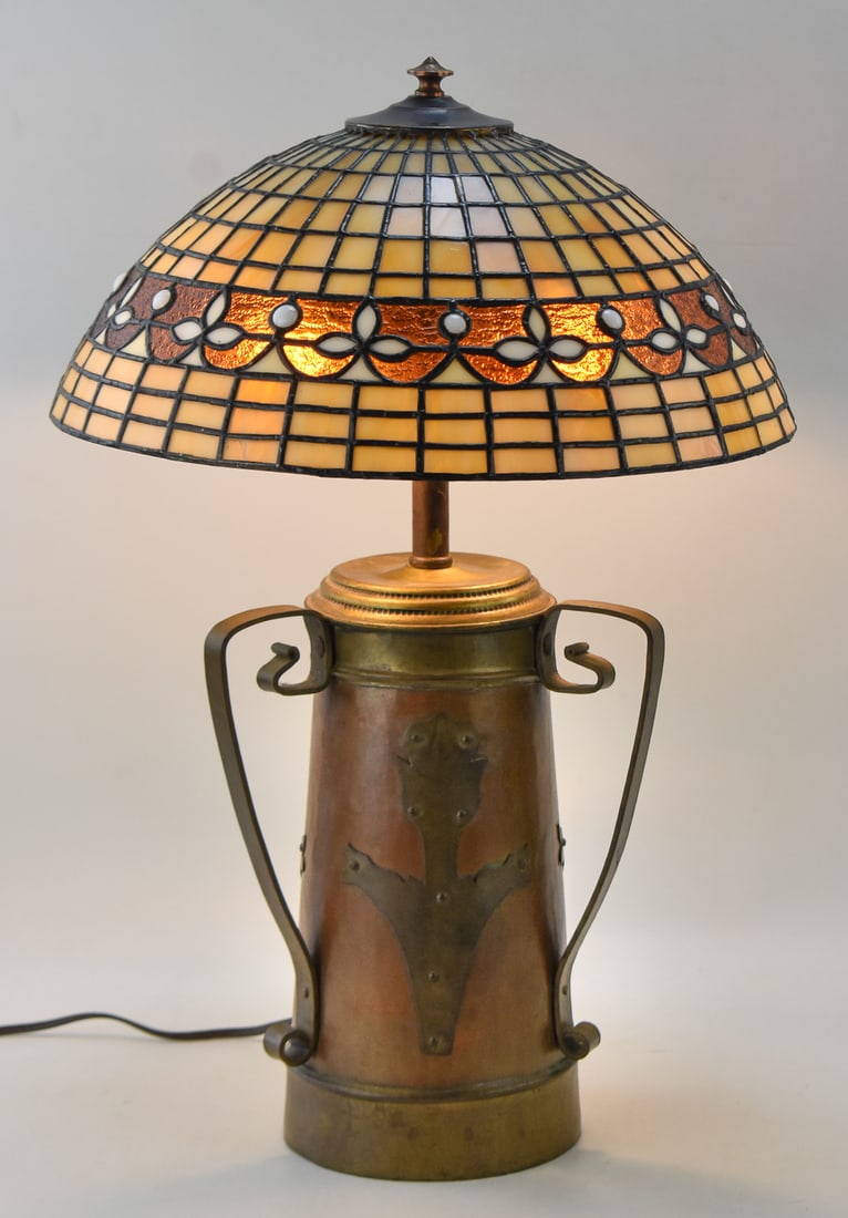 STICKLEY BROTHERS (ATTR.) ARTS AND CRAFTS THREE-HANDLED COPPER VASE TABLE LAMP: A Stickley Brothers (attributed) Arts and Crafts three-handled copper and brass vase repurposed into a table lamp circa 1903. The shade is signed and dated "RPR '87". The item measures 23.5" H, 15" W,