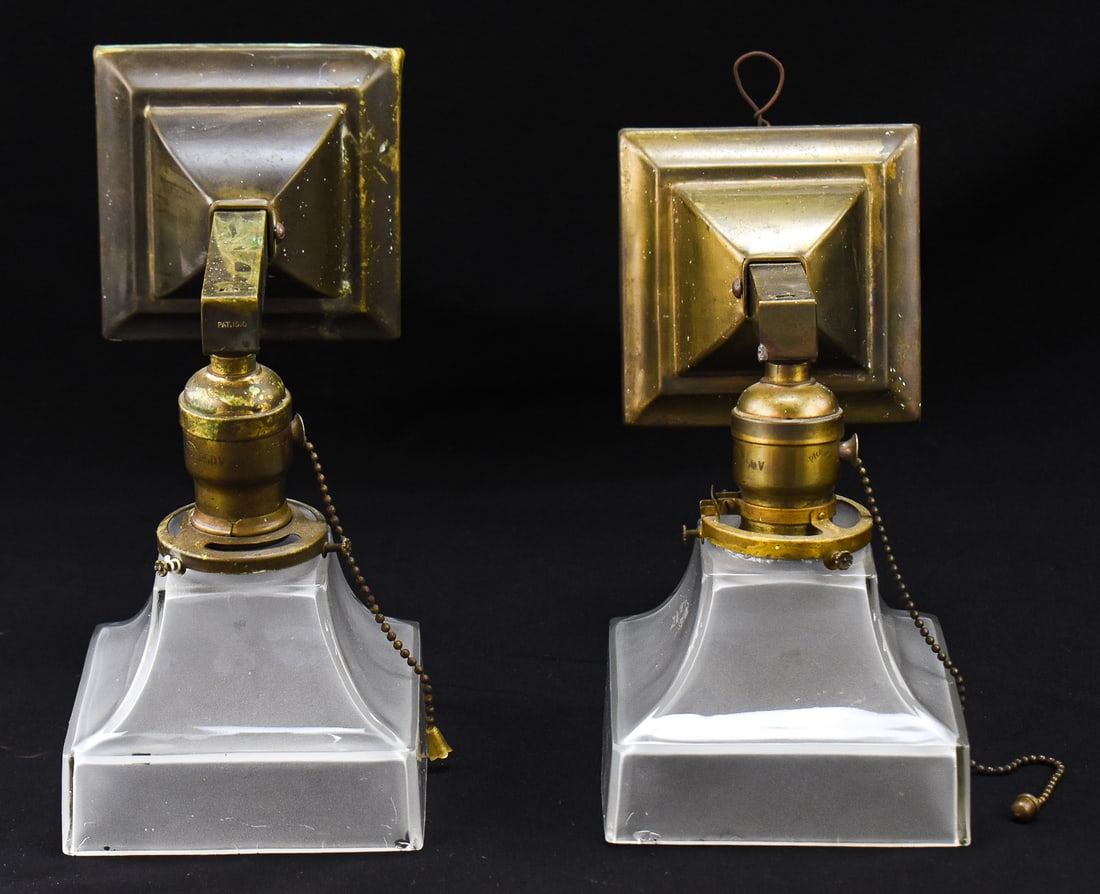 PAIR OF HUBBELL ARTS AND CRAFTS BRASS WALL SCONCES, C. 1910: A pair of Arts and Crafts brass wall sconces made by Hubbell, circa 1910. Each lamp is marked by the maker and displays the patent date. Each sconce also includes an Arts and Crafts square frosted lam