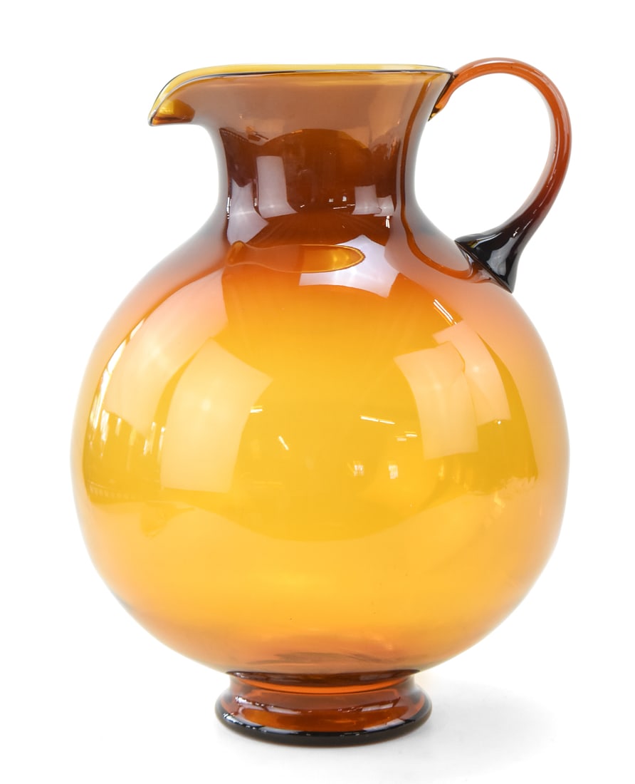 MID-CENTURY INDIANA GLASS COMPANY TIARA EXCLUSIVES AQUARIUS 'HONEY' PITCHER: A very generous sized Mid-century Tiara Exclusives Aquarius "Honey" colored pitcher made by Indiana Glass Company. The item measures 16.5" H x 11" W x 11" D.