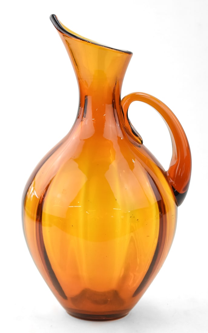 MID-CENTURY BLENKO GLASS OPTIC AMBER PITCHER: A Mid-century Winslow Anderson for Blenko Glass optic amber pitcher measuring 14" H x 7" W x 7" D.
