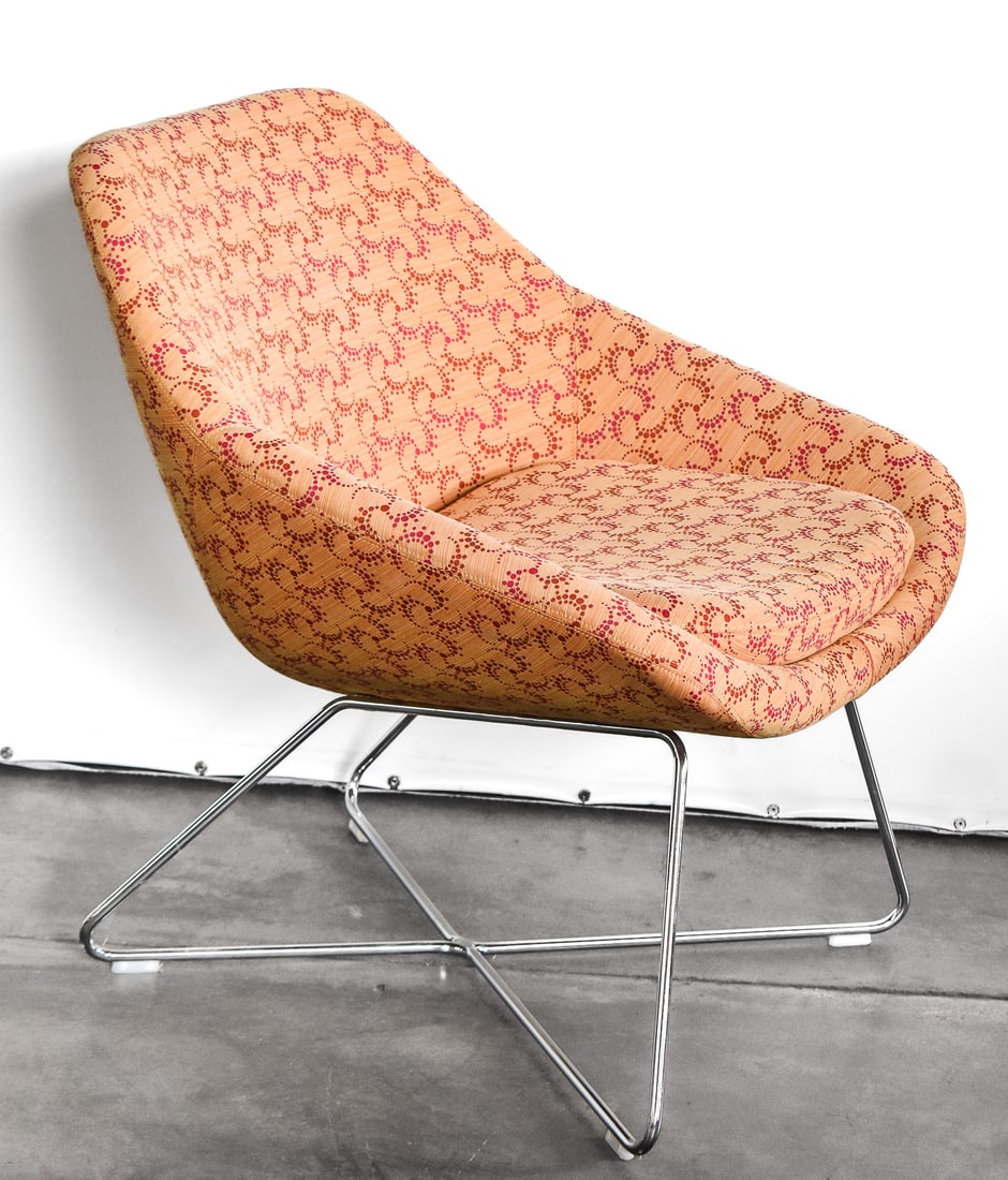 POSTMODERN ALLERMUIR OPEN LOUNGE CHAIR: A Postmodern Allermuir "Open Lounge" chair designed by Pearson Lloyd. It has a steel wire x frame base with peach color fabric and a red pinwheel design. Measures 30" H x 29" W x 27" D.