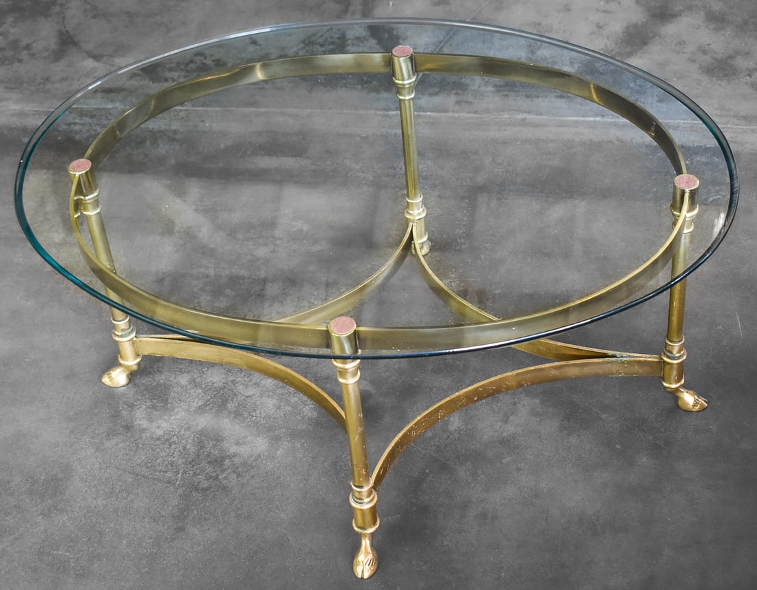 LABARGE HOLLYWOOD REGENCY BRASS & GLASS HOOVED FEET COFFEE TABLE: A Hollywood Regency brass base and glass top coffee table with four hooved deer feet legs, made by LaBarge circa 1960s. The table measures 15.5" H x 30.5" W x 22" D.