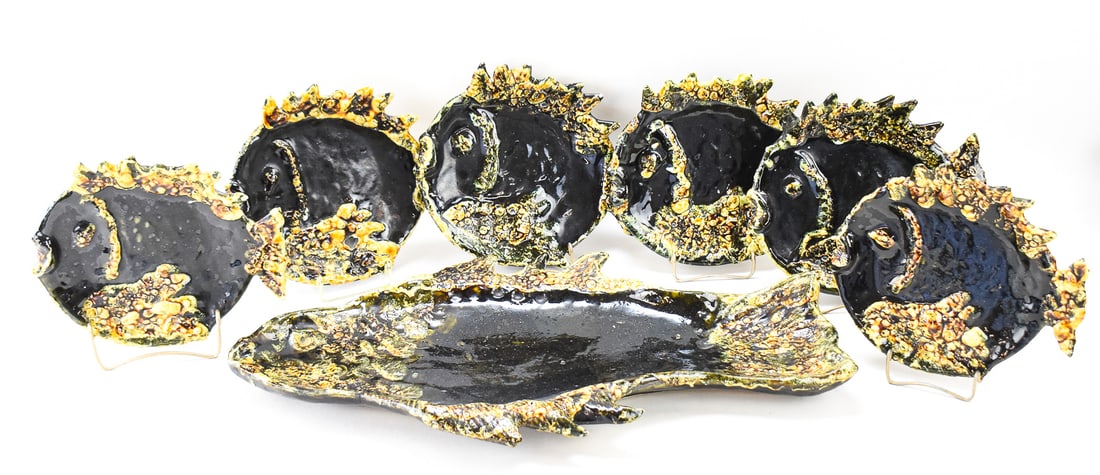 LUC VALLAURIS SIGNED FRENCH FISH SERVICE SET: PLATTER & PLATES: This lot includes a Luc Vallauris signed (French; b. 1913) fish service set in fat lava glaze including one platter and six plates, circa 1960s. The largest item measures 3" H, 24.5" W, 13.5" D.