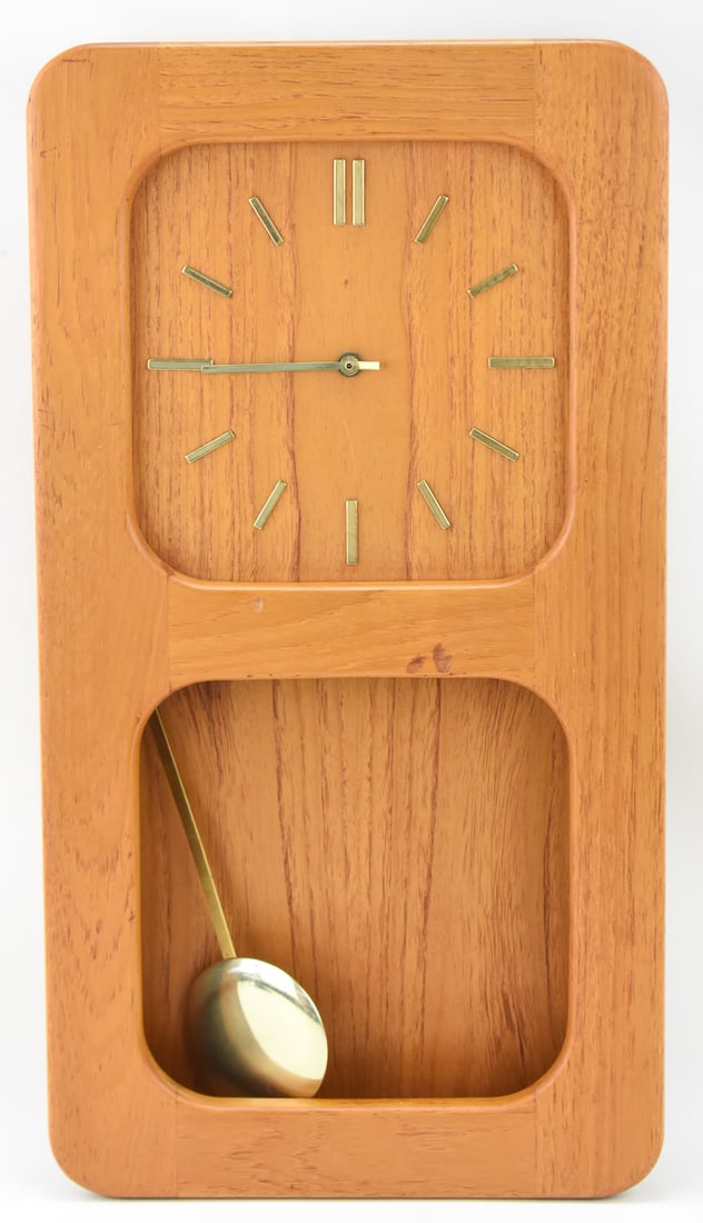 MID-CENTURY DANISH 'DANCLOCK': A Danish "DANclock" wall clock with a pendulum, circa 1960-1970s. The item measures 23.5" H, 13" W, 3" D.