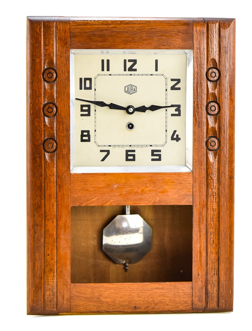ART DECO JURA FRENCH WALL CLOCK, C. 1930s: An Art Deco French Jura wall clock, produced circa 1930s. The case is made of oak with vertical fluted detailing on the sides. Includes a clock key and the pendulum. The clock measures 19.5" H x 13.5 