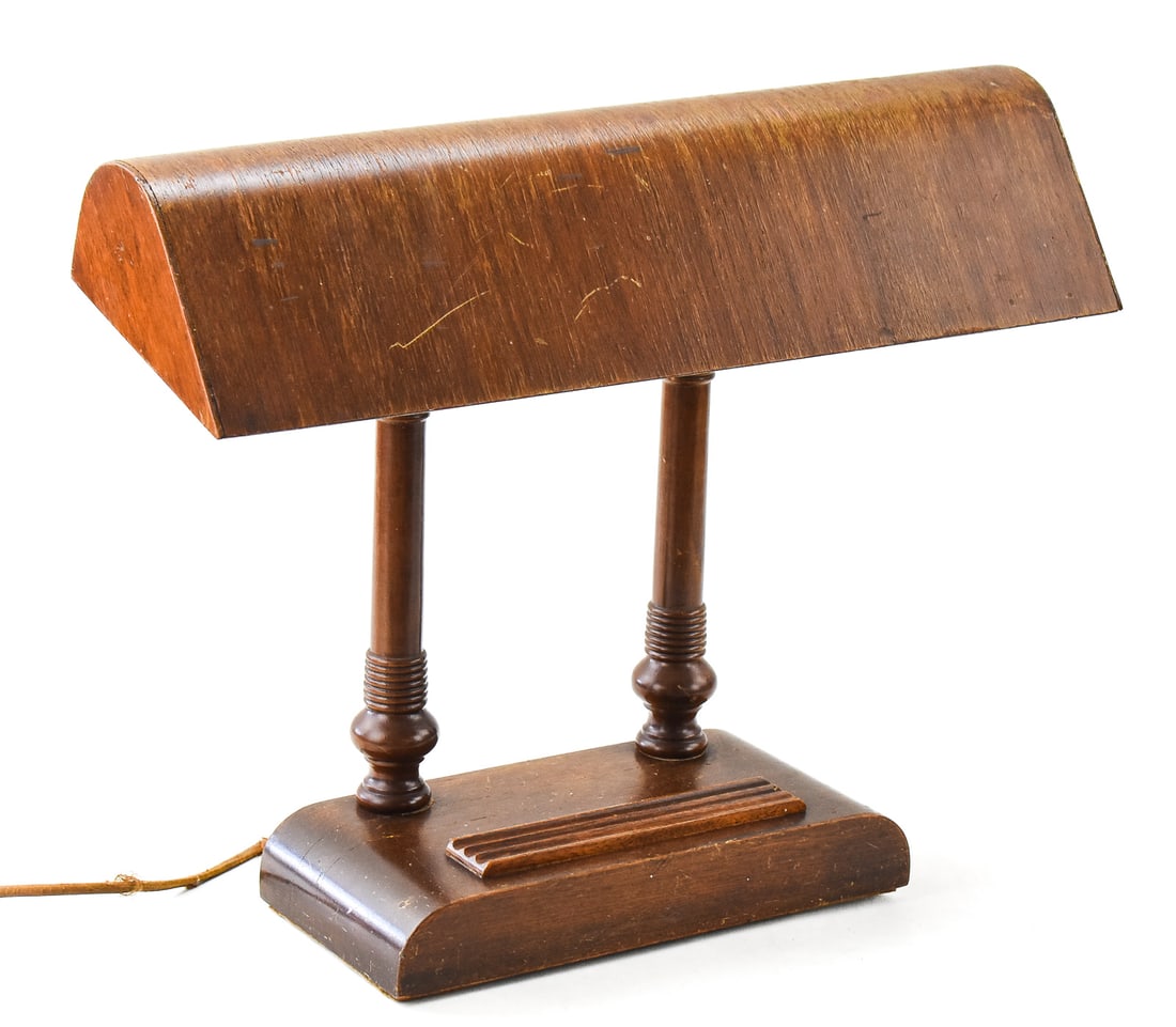 ART DECO STYLE WOOD BANKER'S/PIANO LAMP: An Art Deco style wood banker's or piano lamp with a wooden base and a wooden "airplane wing" style lamp shade, circa 1930-1950s. The lamp measures 16" H x 19" W x 6" D.