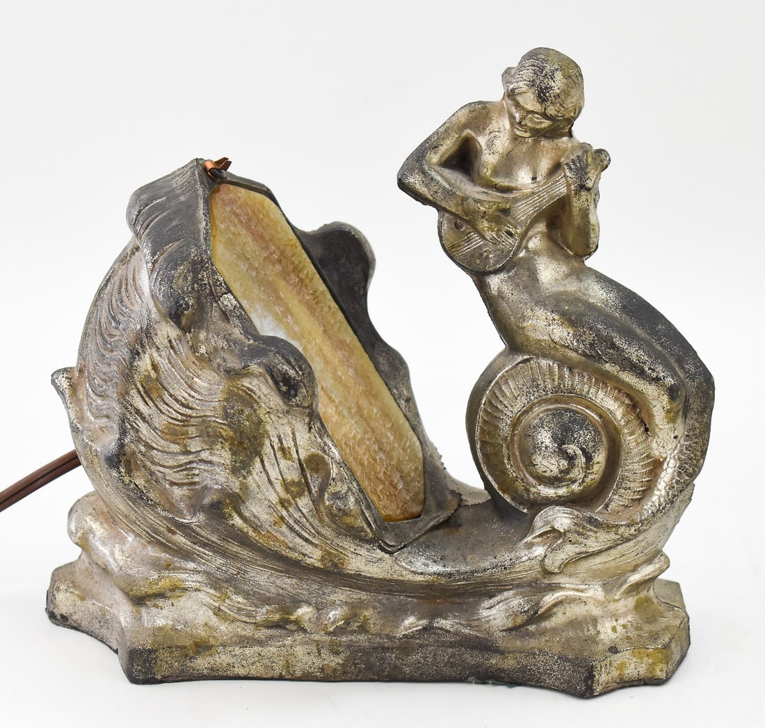 MERMAID FIGURAL TABLE LAMP, EARLY 20TH CENTURY: A mermaid playing a lute figural electric table lamp with a slag glass insert, circa early 20th century. The item measures 9" H, 9" W, 5" D.