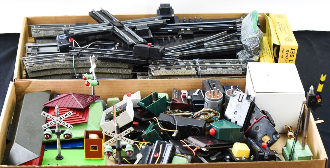 COLLECTION OF RAILWAY TRACKS, TRAIN ACCESORIES AND TRAIN BOOKS: All pieces come from the brand of American Flyers. Railway tracks include the following; 726 Straight Rubber Roadbed, 727 Curved Rubber Roadbed, (3) 712 Special Rail Sections, 725 Cross Intersection,