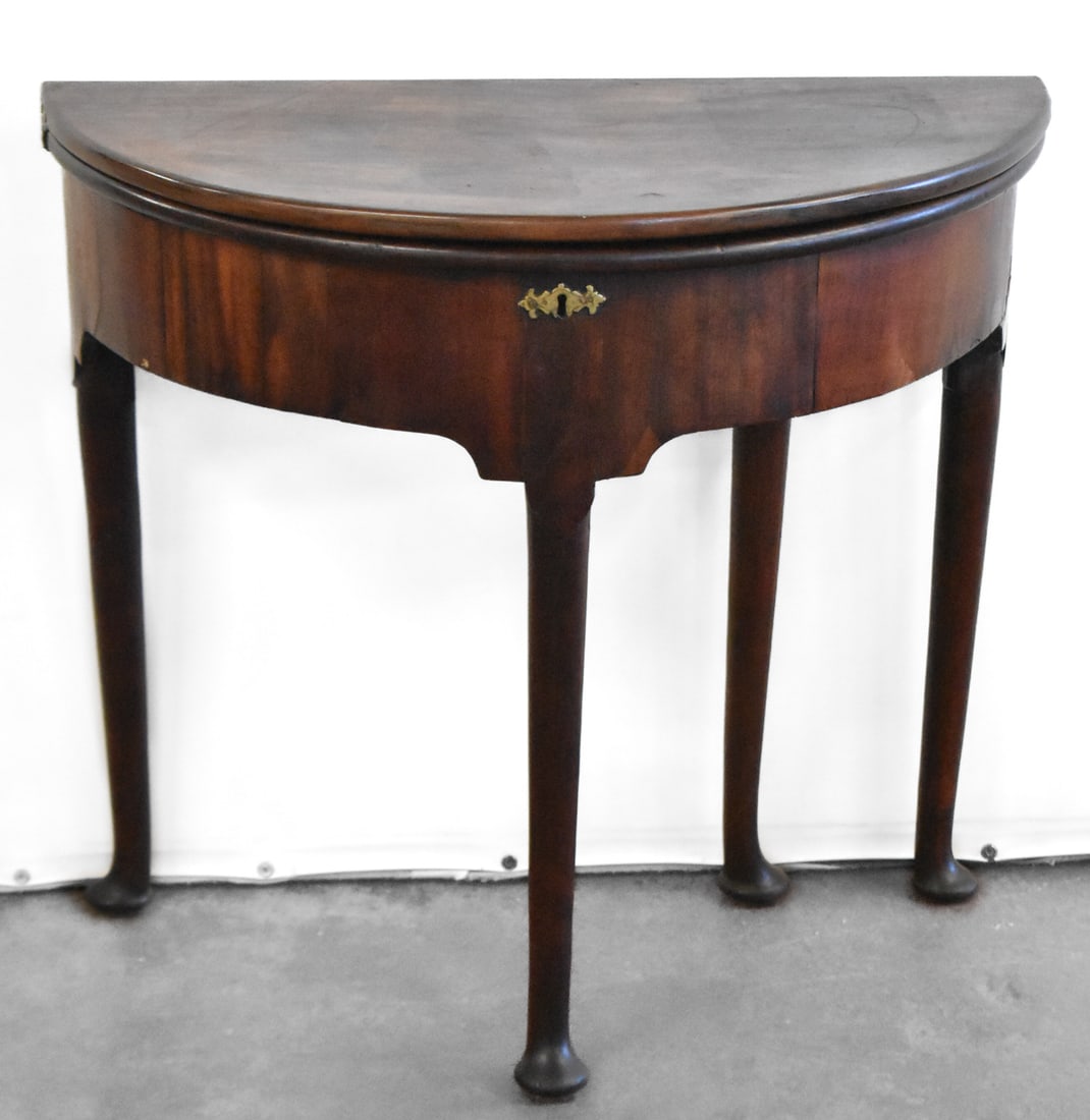 GEORGE lll STYLE DEMI-LUNE TABLE: This half moon, folding top table is made of mahogany with slender legs featuring spade feet. This is a metamorphic table top so it folds into a full circle top.