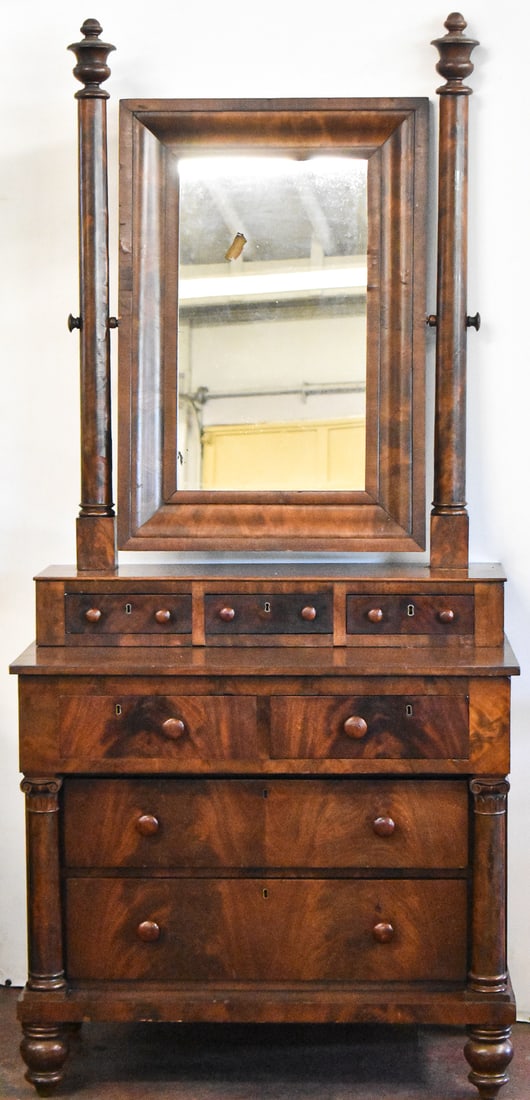 FLAME MAHOGANY DRESSER WITH TILT MIRROR, C. MID 19TH CENTURY: A flame mahogany dresser with a tilt mirror with carved supports and seven drawers, circa mid-19th century. The dresser measures 80" H x 36.5" W x 22.5" W
