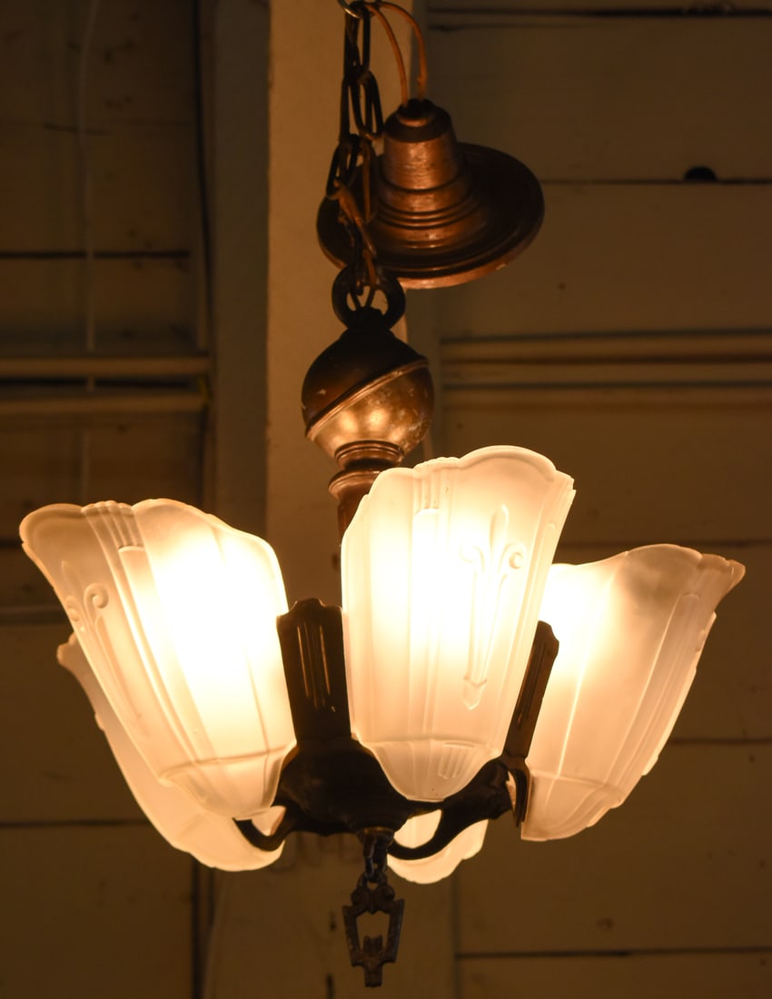 LINCOLN ART DECO SLIP SHADE CHANDELIER, C. 1930s: An Art Deco frosted slip shade five-light chandelier made by Lincoln Manufacturing, produced circa 1930s. The chandelier body measures 17" H x 16" W x 16" D.