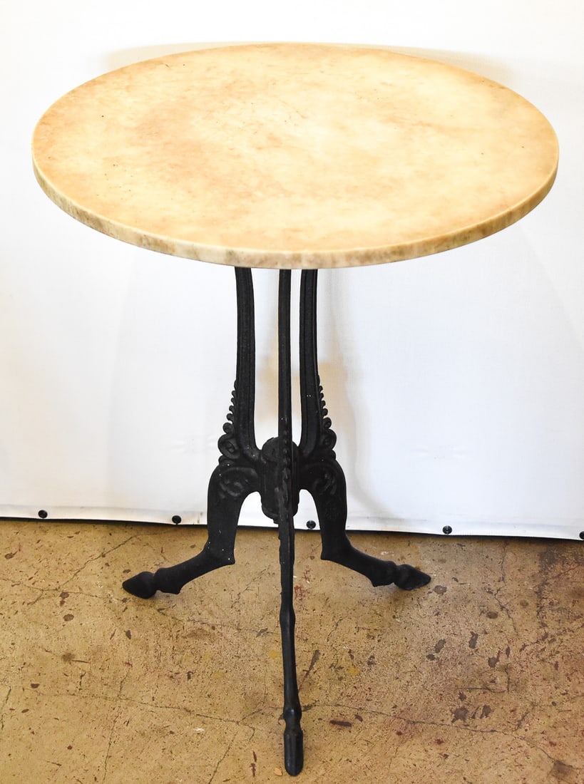 ENGLISH MARBLE TOP CAST-IRON BISTRO TABLE, LATE 19TH CENTURY: An English cast iron table with a marble top. The table is marked "W. B. 1888" on the joint where the legs meet, and has British Registry marks on each of the cast iron legs dating the table to the
