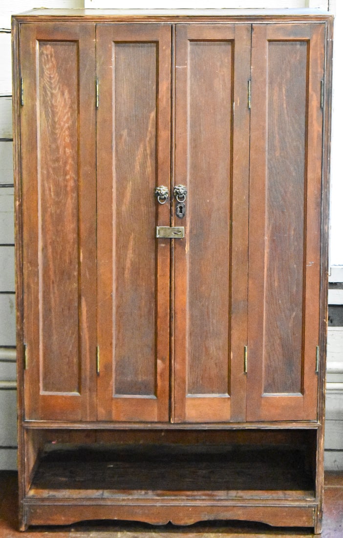 OAK GENTLEMAN'S WARDROBE, C. EARLY 20TH CENTURY: An oak gentleman's wardrobe with double-paneled doors, a lower storage drawer, and two upper shelves, made circa early 20th century. The wardrobe measures approx. 50" H x 30" W x 18" D.