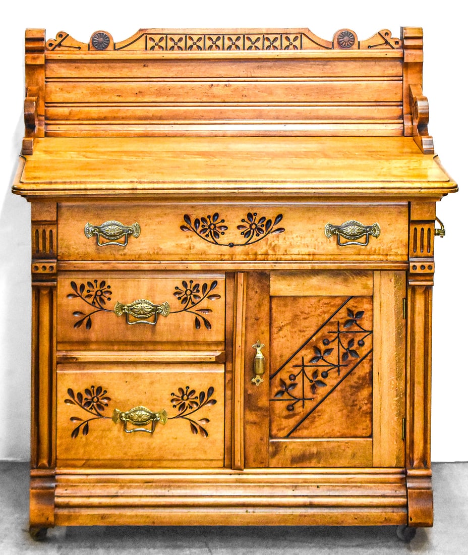 VICTORIAN WALNUT WASHSTAND WITH SPOON CARVINGS: A Victorian walnut washstand with intricate spoon carvings. The washstand has four drawers, one cabinet, a brass towel bar on the right side and is on castors. It measures approx. 37" H x 32" W x 18"