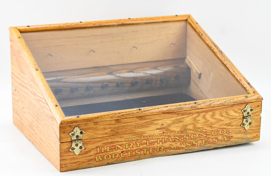 COUNTERTOP DISPLAY CASE, HENRY L. HANSON COMPANY, EARLY 20TH CENTURY: A countertop oak and glass display case made by the Henry L. Hanson Company of Worcester, Massachusetts, circa early 20th century. The display box has hanging nails on the inside as well as magnetic
