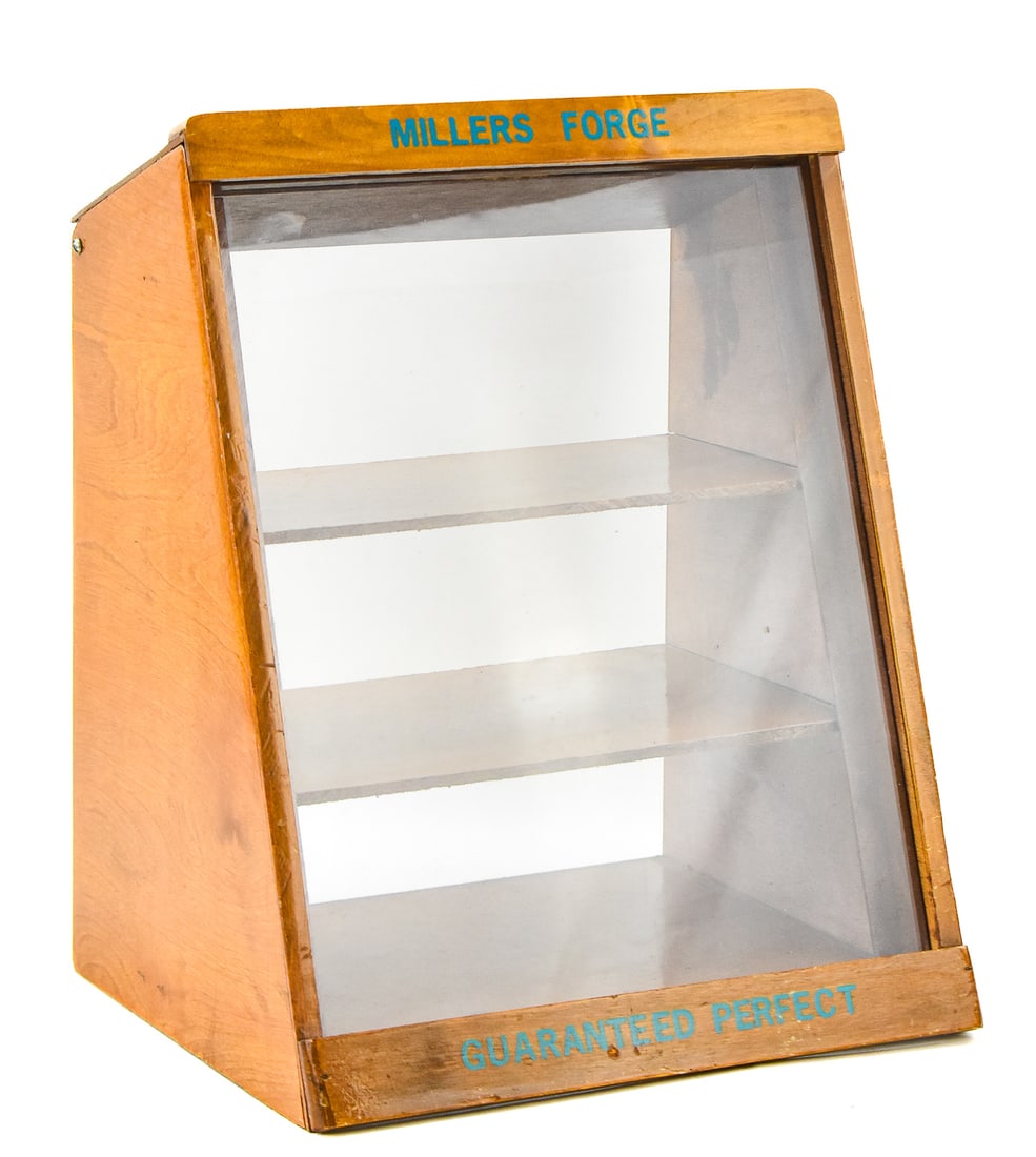 MILLER'S FORGE TABLETOP DISPLAY CASE: Wood and glass display case with Miller's Forge branding and a stepped back design. It measures approx. 16" H x 13" W x 11" D.